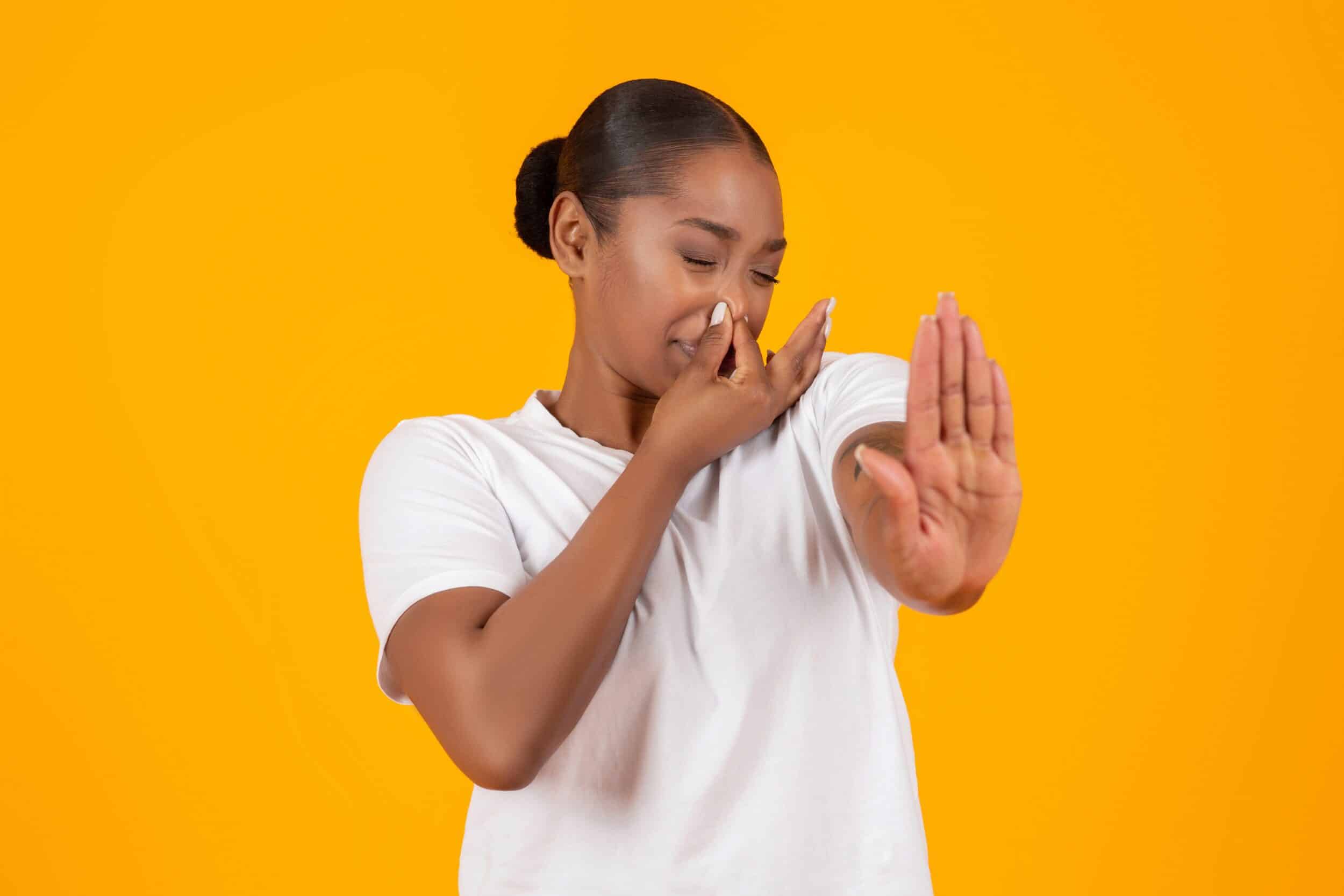 Woman plugging her nose to avoid smelling harsh cleaning products before using Clean Habits