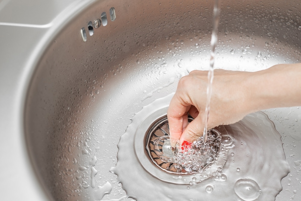 Woman closing her drain after using a probiotic drain cleaner