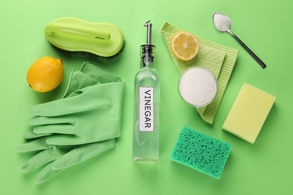 Vinegar, baking soda, and lemon being used as alternatives to harsh cleaning products